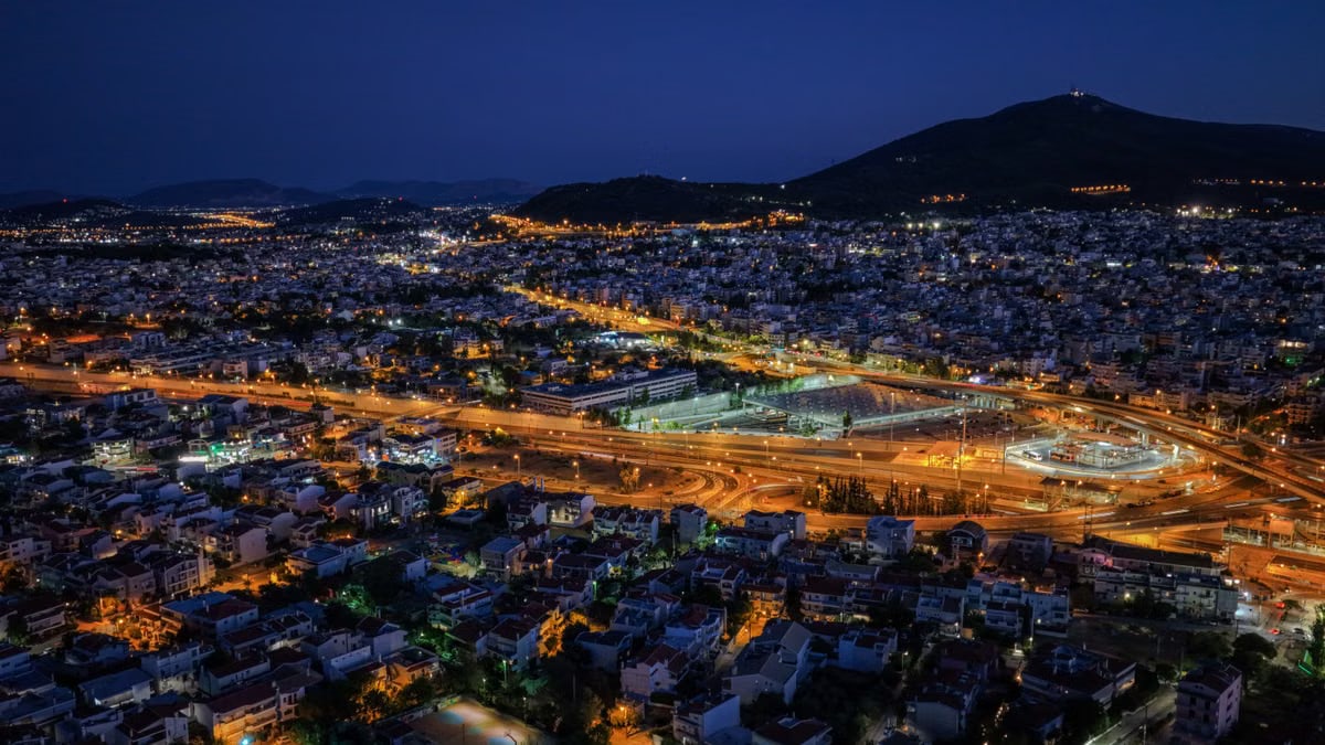 Stunning aerial view of Vrilissia, Greece at night with city lights illuminating the landscape.